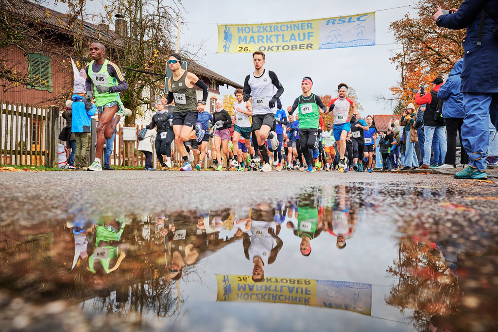 LäuferInnen unter dem Transparent beim Holzkirchner Marktlauf 2025